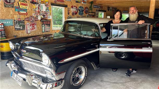 US-Car Treffen in Nordenham: Fachsimpeln über schöne Motorengeräusche Paar steht in der geöffneten Autotür eines Chevys.