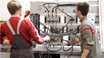 Bremerhaven: Lehrstellensuche bleibt Herausforderung für junge Leute Zwei junge Männer stehen an einer hydraulischen Anlage