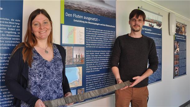 Grabungen in Butjadingen auf alten Wurten: Forscher berichten von ihrer Arbeit Eine Frau und ein Mann gucken in die Kamera. Sie stehen im Nationalparkhaus Museum Fedderwardersiel.