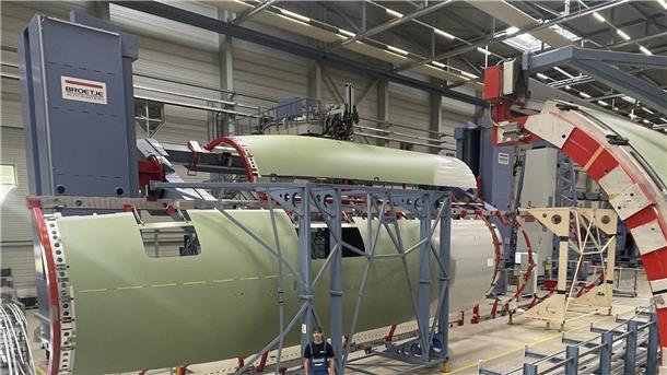 Von der Skizze zum Rumpf: Wie Airbus Flugzeuge zum Leben erweckt Mann vor einem Flugzeugrumpf in der Fertigungshalle