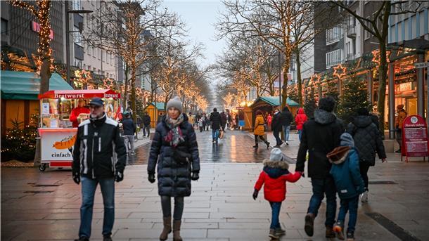 Menschen laufen durch die weihnachtlich geschmückte Einkaufsstraße in Bremerhaven. 