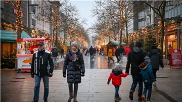 Menschen laufen durch die weihnachtlich geschmückte Einkaufsstraße in Bremerhaven. 