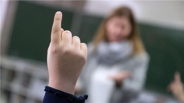Lehrermangel in der Wesermarsch: Noch keine Antworten auf offene Fragen Ein Kind meldet sich im Unterricht. Man sieht nur die Hand.