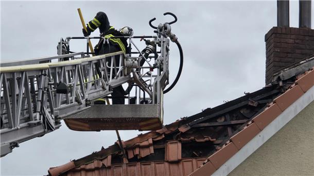 Nach Brand in Langener Wohngruppe: Wo sind die Jugendlichen geblieben? Ein Feuerwehrmann auf einer Drehleiter nimmt Dachziegel mit einem Stab ab.