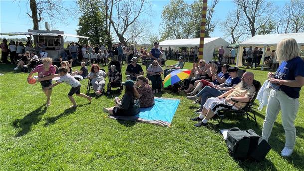 Eine Gruppen von Menschen sitzt auf Stühlen in der Sonne. Zur Maifeier im Landhuus Bieber in Isens strömten die Besucher nur so.