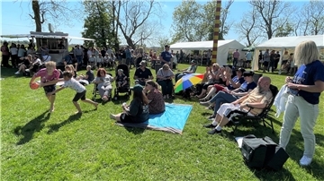 Eine Gruppen von Menschen sitzt auf Stühlen in der Sonne. Zur Maifeier im Landhuus Bieber in Isens strömten die Besucher nur so.