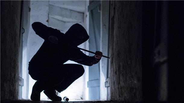 Einbrüche in Keller in Bremerhaven - Polizei gibt Tipps zum Schutz Ein fiktiver Einbrecher hebelt mit einem Brecheisen eine Tür im Keller eines Wohnhauses auf.