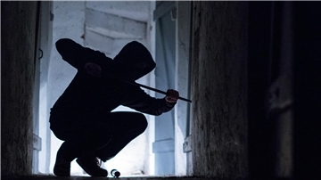 Einbrüche in Keller in Bremerhaven - Polizei gibt Tipps zum Schutz Ein fiktiver Einbrecher hebelt mit einem Brecheisen eine Tür im Keller eines Wohnhauses auf.