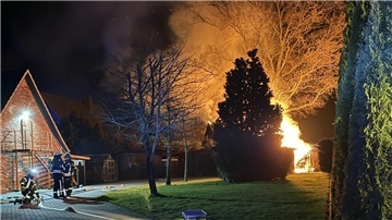 Feuerwehrleute löschen die Flammen eines Brandes. In Heeslingen hat ein Schuppen gebrannt. Die Feuerwehr verhinderte ein Übergreifen der Flammen.