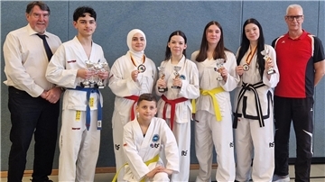 Hans Hortig (Kampfrichter), Asim Kürekci, Amine Güngör, Julianna Smailov, Maja Saathoff, Emily Smailov, Bernd Strahlmann (Trainer) und (kniend) Erkam Güngör