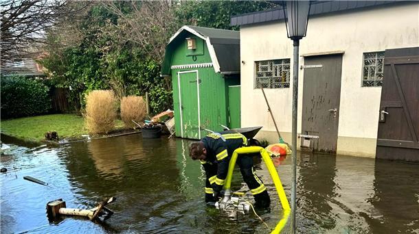 Hochwasser: Diese Einsätze gab es bislang in der nördlichen Wesermarsch Ein Feuerwehrmann pumpt Wasser aus einem überschwemmten Garten