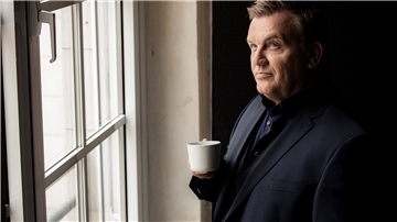 Hape Kerkeling trinkt einen Kaffee am Fenster.