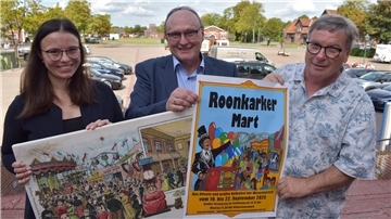 In Vorfreude auf den 890. Roonkarker Mart zeigen Ordnungsamtsleiterin Angelika Müchler, Bürgermeister Harald Stindt (Mitte) und Schausteller-Sprecher Dietrich Meier eine historische Darstellung und das aktuelle Plakat.