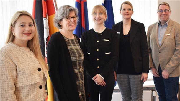 Olena Palahnyuk, Doris Ammermann,  Hannah-Sophie Heldberg, Maren Würger, Marco Witthohn stehen in einer Reihe vor einem Fenster. Hinter ihnen stehen Flaggen. 