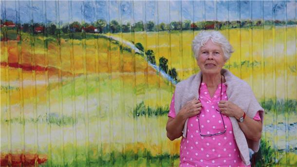 Inge van de Felde vor dem Tor Nr. 5 mit dem Bild „Düker Groden“ .
