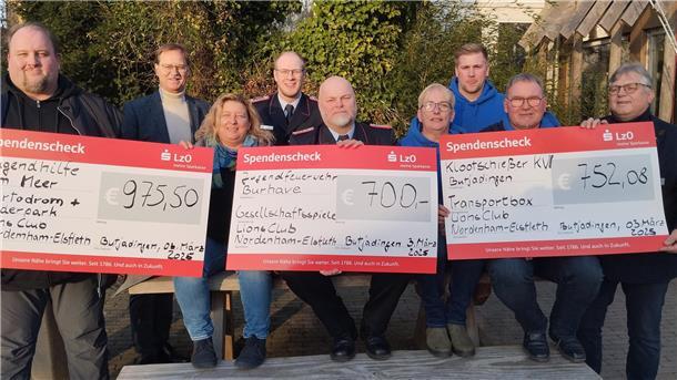 Eine Gruppe von Menschen hält drei Spendenschecks in die Höhe. Der Lions-Club Nordenham/Elsfleth hat das Geld aus der Adventskalender-Aktion an drei Organisationen gespendet.