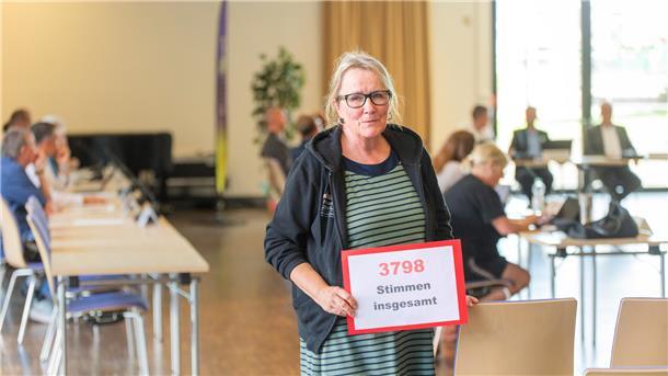 Ingrid Zahn, Leiterin des Familienzentrums „Louise-Schroeder-Straße“, präsentiert im Ausschuss für Bürgerbeteiligung das Plakat „3798 Stimmen“ für den Erhalt der Familienzentren.