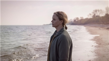 Iris (Sofia Helin) versucht, sich am Strand in Ystad zu entspannen