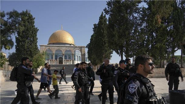 Gewalt am Tempelberg, Raketen aus Gaza und Gegenangriff Israelische Polizisten eskortieren eine Gruppe jüdischer Männer zum Tempelberg in der Altstadt von Jerusalem - im Hintergrund die Al-Aqsa-Moschee.
