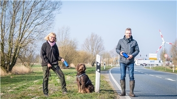 Jagdpächterin Heike Hauenschild und Holger Lehmgrübner aus der Geschäftsführung der Bremerhavener Tier- und Naturschutzstiftung bringen die Wildwarnreflektoren an.