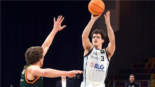 Ein Basketballer wirft auf den Korb.