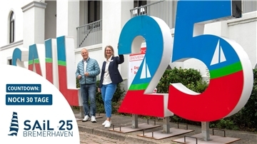 Jens Grotelüschen (links) und Havenhostel-Regionalleiterin Andrea Schirmer präsentieren den SAIL-Schriftzug.