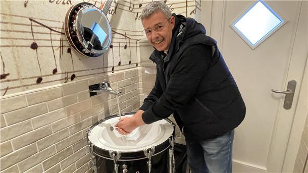 Schöner Müssen in Tossens: Das sind die wohl rockigsten Toiletten des Nordens Ein Mann wäscht sind an einer zum Waschbecken umfunktionierten Basstrommel die Hände. Es ist der Tossenser Konzertmuschel-Betreiber Jens Hillers.
