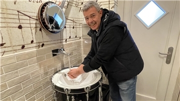 Ein Mann wäscht sind an einer zum Waschbecken umfunktionierten Basstrommel die Hände. Es ist der Tossenser Konzertmuschel-Betreiber Jens Hillers. 