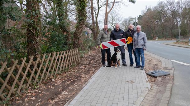 Jörg Appiarius (von links), Kolja und Kevin Kuske sowie Matthias Träger und Kuskes Familienhund Bolle sind stolz auf den neuen Fußweg an der K14 in Wanhöden. Zusammen mit einer Handvoll Helfer haben sie das Bauwerk in Eigeninitiative realisiert.
