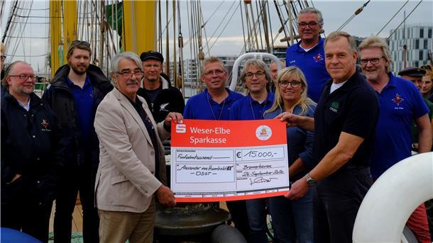 Jörg Schinzer, Vorsitzender der S.T.A.G. (Mitte links), überreicht Jörg Peter Berendsen, Kapitän der „Alexander von Humboldt II“ (Mitte rechts), einen Scheck in Höhe von 15.000 Euro für ein neues Navigationssystem.