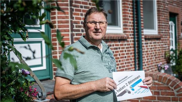 Weniger Anerkennung für Ehrenamt Ein Mann hält einen Wahlzettel in der Hand.