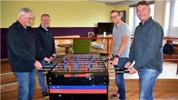 Das Foto zeit den neuen Jugendzentrumsleiter Stefan Gaudies mit Gemeindevertretern beim Tischkicker. 