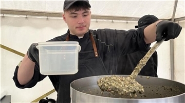 junger Mann serviert Grünkohl