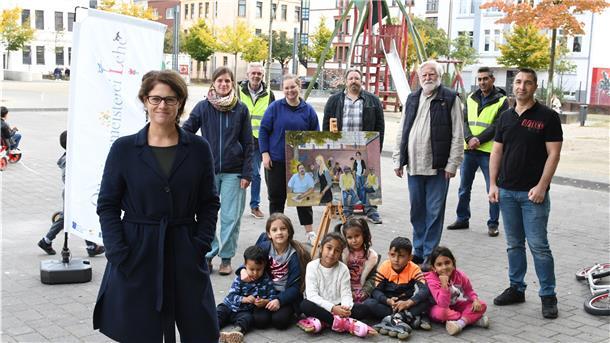 Junge Nutzer sitzen umringt von den Kräften, die auf dem Leher Pausenhof für Programm sorgen (von links): Nora Wieczorek und Miriam Gieseking (Quartiersmeisterei), Manfred Maas (AFZ-Umweltwächter), Bildungsbuddy Elisa Kriege, Cafer Isin (Quartiersmeisterei), Anwohner Wolf Truhart, Fanar Hamo (AFZ-Umweltwächter) und Bildungsbuddy Memet Özkisi.