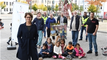 Junge Nutzer sitzen umringt von den Kräften, die auf dem Leher Pausenhof für Programm sorgen (von links): Nora Wieczorek und Miriam Gieseking (Quartiersmeisterei), Manfred Maas (AFZ-Umweltwächter), Bildungsbuddy Elisa Kriege, Cafer Isin (Quartiersmeisterei), Anwohner Wolf Truhart, Fanar Hamo (AFZ-Umweltwächter) und Bildungsbuddy Memet Özkisi.
