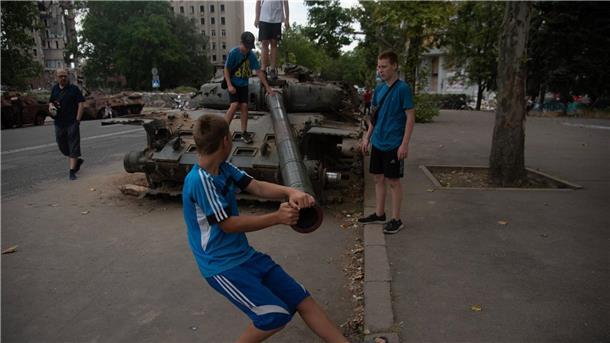 Krieg gegen die Ukraine: So ist die Lage Jungen spielen an einem zerstörten russischen Panzer, der auf einer Straße von Mykolajiw steht.