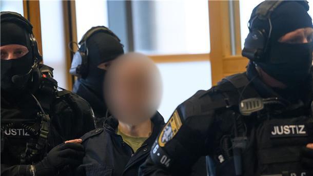 Nach Geiselnahme im Gefängnis: Urteil gegen Halle-Attentäter Justitzbeamte führen den Angeklagten in den Gerichtssaal in Magdeburg.