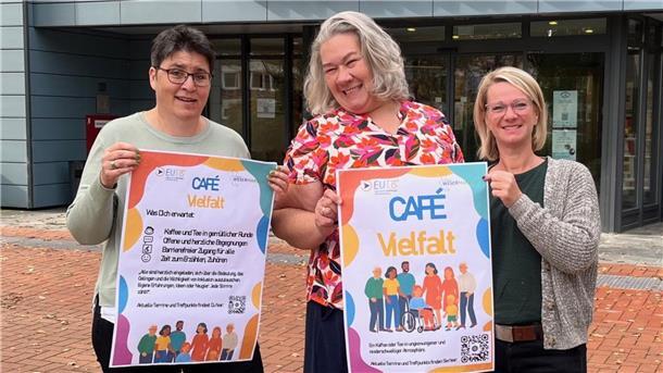 Drei Frauen mit einem Plakat, mit dem sie das „Café Vielfalt“ in der Wesermarsch bewerben.