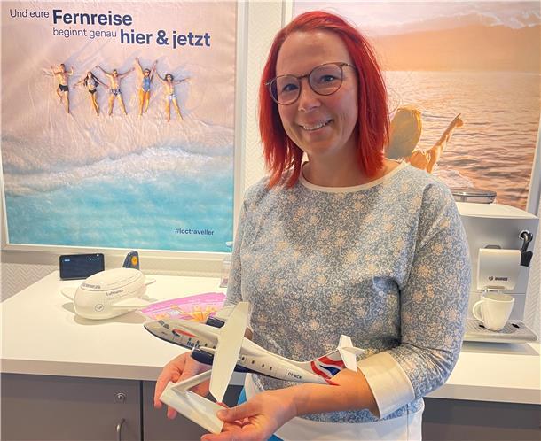 Nordenhamer Reisebüros geben Tipps, wie man günstig in den Urlaub fliegt Frau mit Modellflugzeug in der Hand.