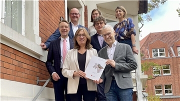 Karin Beckmann überreicht die Mittelteilung zum Programmjahr 2025 der Stadt Zeven an Bürgermeister Jens Petersen und Stadtdirektor Henning Fricke.