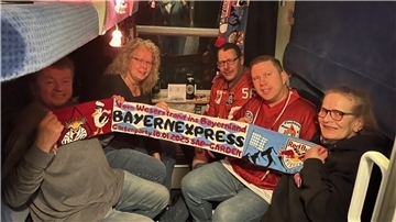 Eishockey-Fans halten einen Schal hoch.