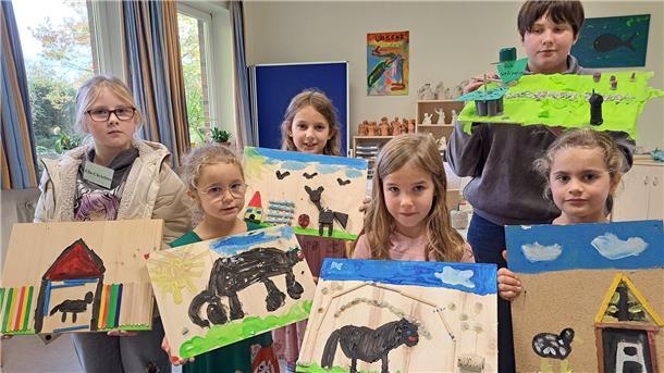 Bild von Ella-Christina, Johanne, Johanna, Jonte, Matthea und Malene, die ihre Glücksstädte präsentieren, die sie während der Kinderbibelwoche der Kirchengemeinde Nordenham gemalt und gebastelt haben.