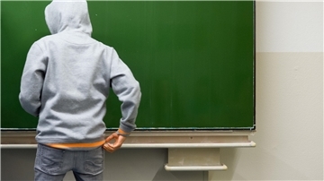 Ein Schüler steht an der Tafel.