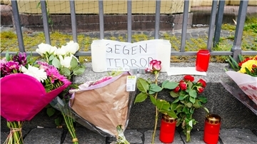 Kerzen, Blumen und ein Blatt Papier mit der Aufschrift „Gegen Terror“ stehen am Tatort auf dem Mannheimer Marktplatz.