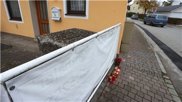 Kerzen und Blumen stehen vor dem Haus in Weilheim, in dem die getöteten Schwestern entdeckt wurden.