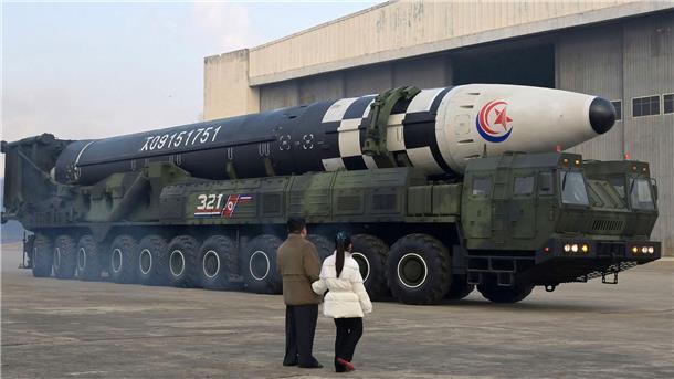 Kim Jong-un geht nach nordkoreanischen Angaben in Begleitung seiner Tochter vor einem Militärfahrzeug mit einer Rakete entlang.