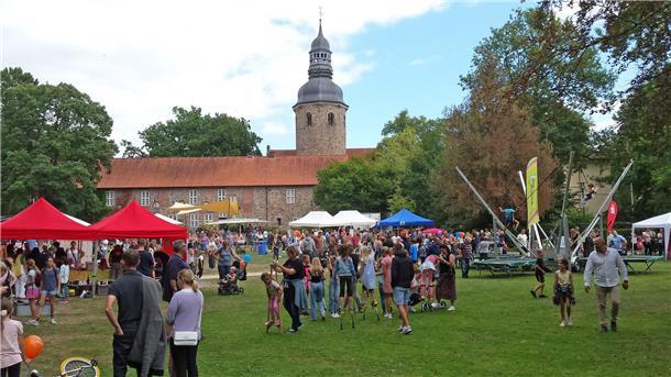 Menschen besuchen verschiedene Aktionen in einem Park.