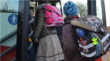 Kinder steigen in einen Schulbus.