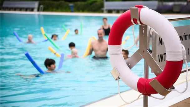 Mehr Kinder schwimmen sicher Kinder üben in einem Außenbecken das Schwimmen.