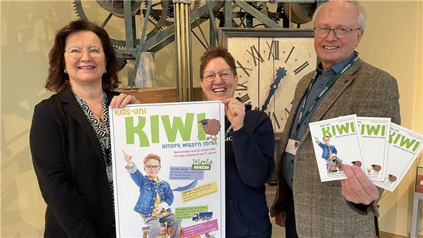 Zwei Frauen und ein Mann mit Plakaten und Flyern in den Händen. Kirstin Förder-Parohl, Svenja Faehse und Dr. Timothy Saunders gegen den Startschuss für die Wiederauflage der Nordenhamer Kinder-Uni Kiwi.
